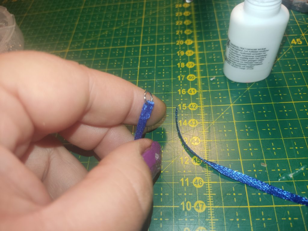 Blaues Satinband mit Ring am Ende.